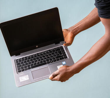 Person showing one of our second-hand laptops.