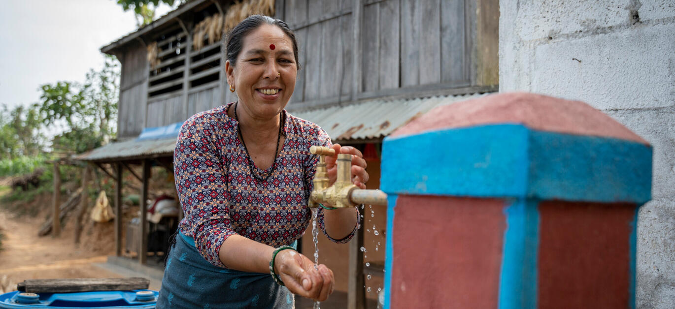 Pampha Pariyar se lave les mains au robinet installé par Oxfam