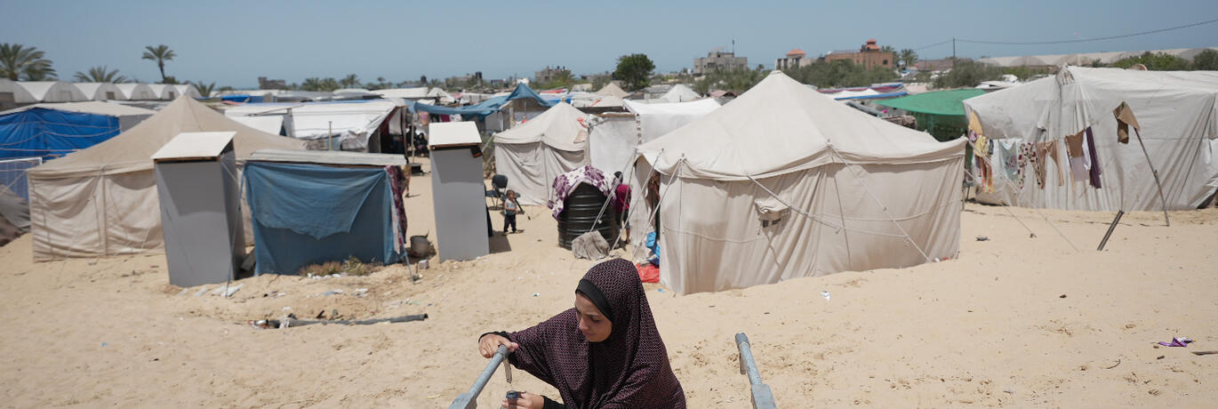 gaza women taking water from tap installed by Oxfam