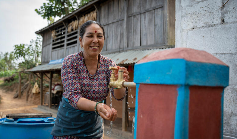Pampha Pariyar se lave les mains au robinet installé par Oxfam