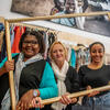 3 vrouwen poseren in een kader in een Oxfam-Tweedehandswinkel.