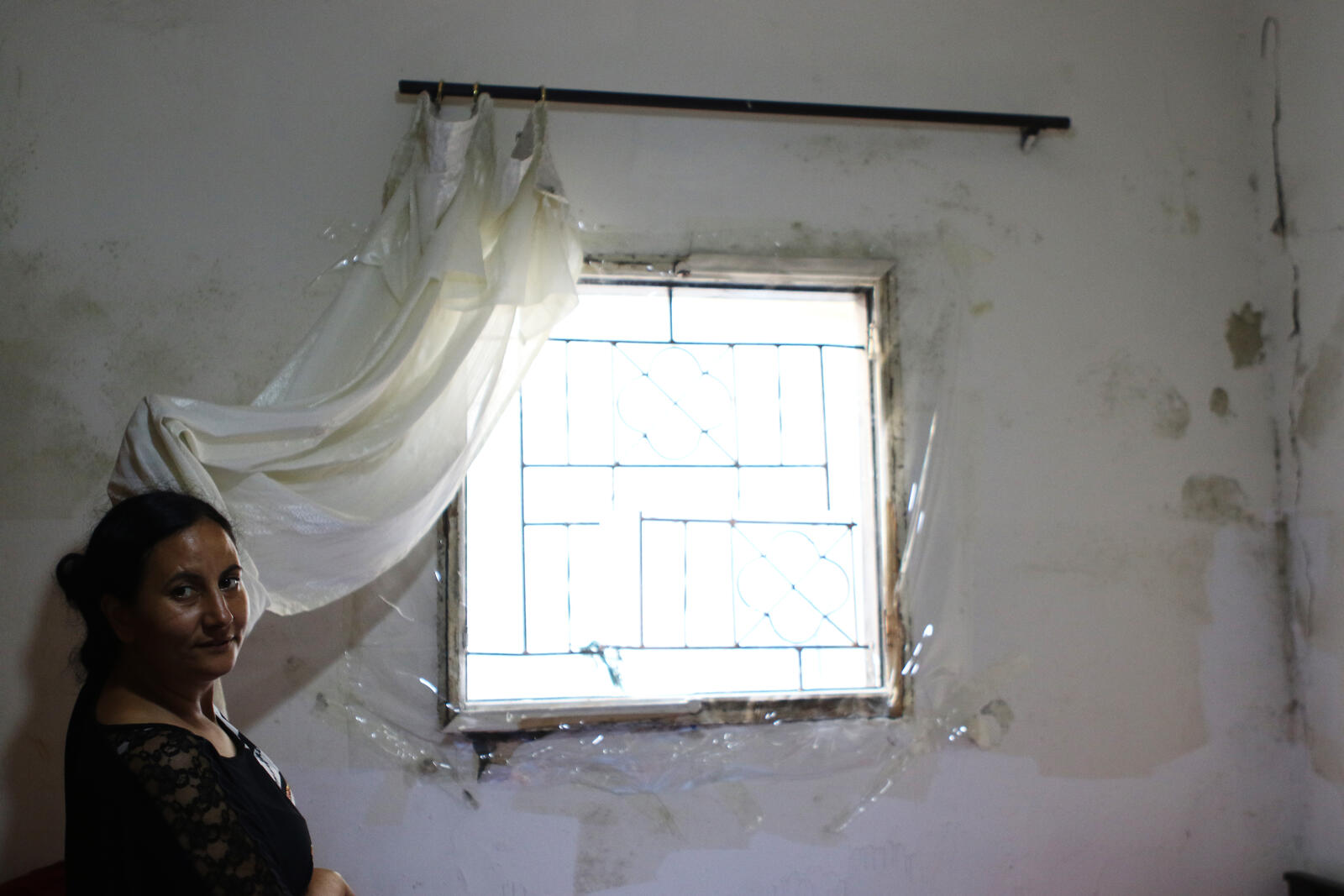 Hanaa shows the broken window in her bedroom